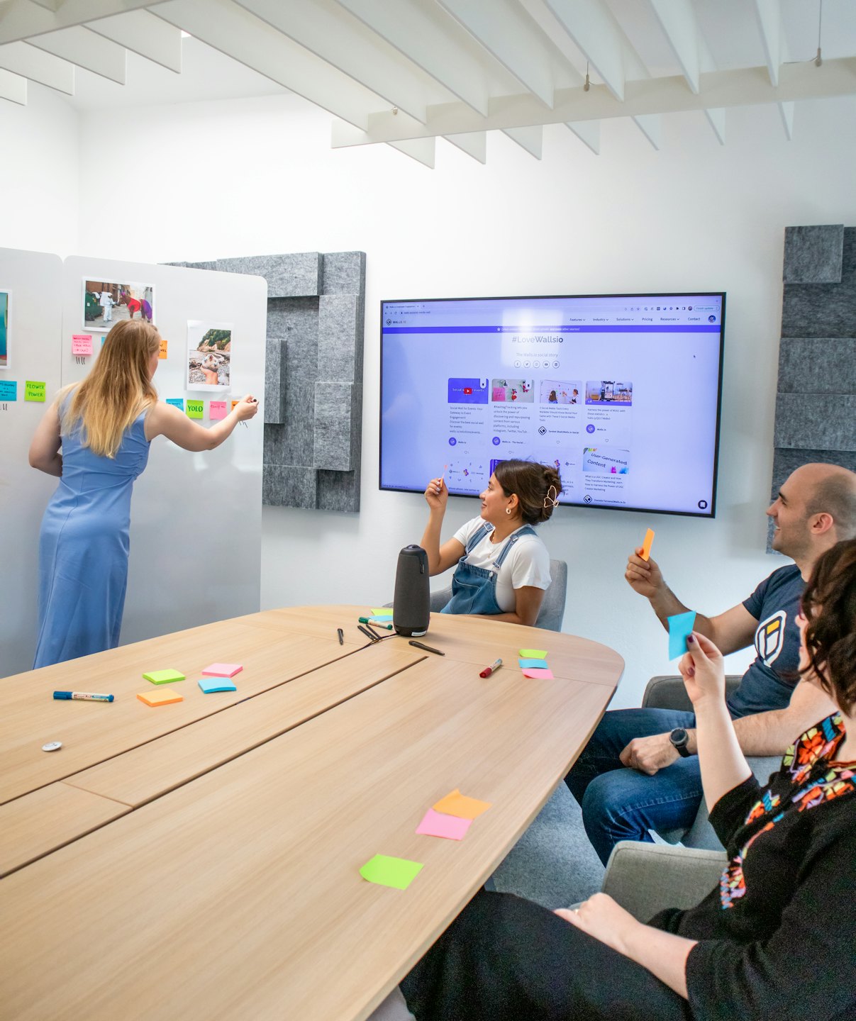 Team eterogeneo che fa brainstorming davanti a un monitor e post-it.