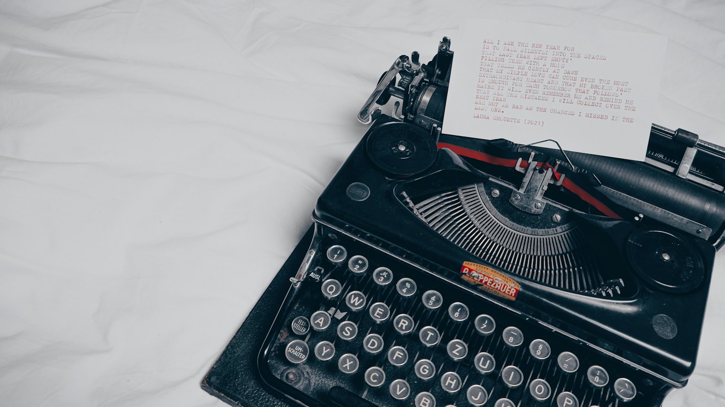 Macchina da scrivere vintage con poesia rossa su carta bianca.